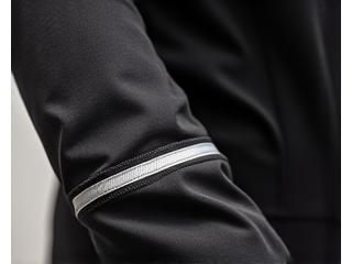 Close-up of reflective tape on cycling jacket sleeve, reflecting light